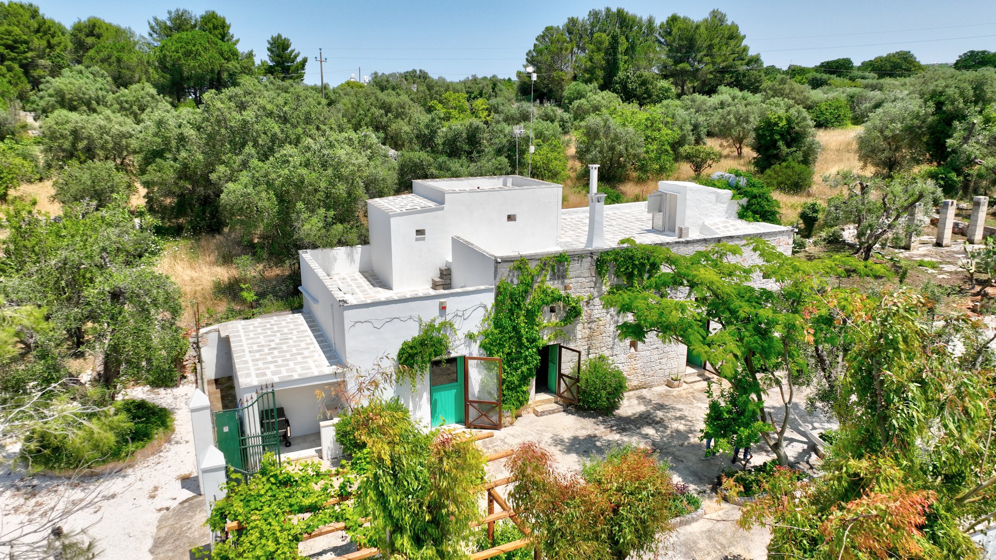 Aerial view of Masseria Bel Cortile among the olive trees in Ostuni, Valle d'Itria