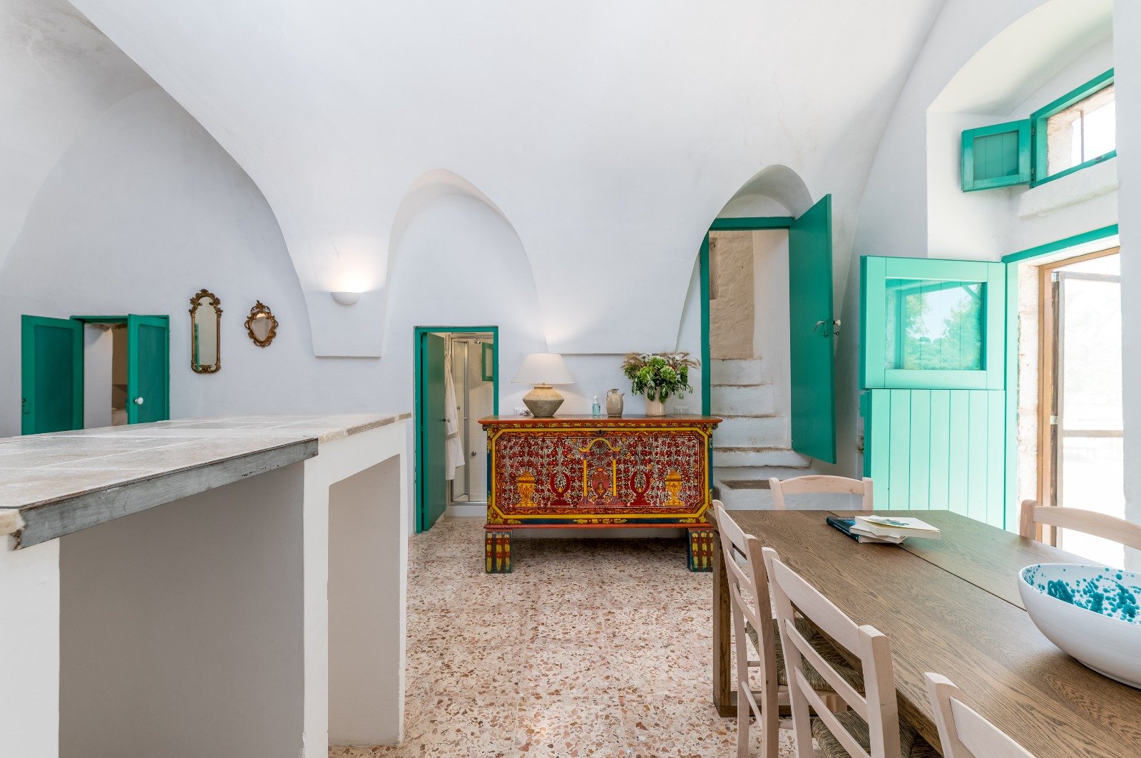 Kitchen and living area with green window frames at the masseria in Ostuni