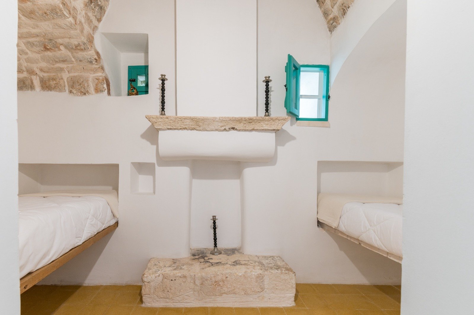 Interior with a stone niche and white vaults at the masseria