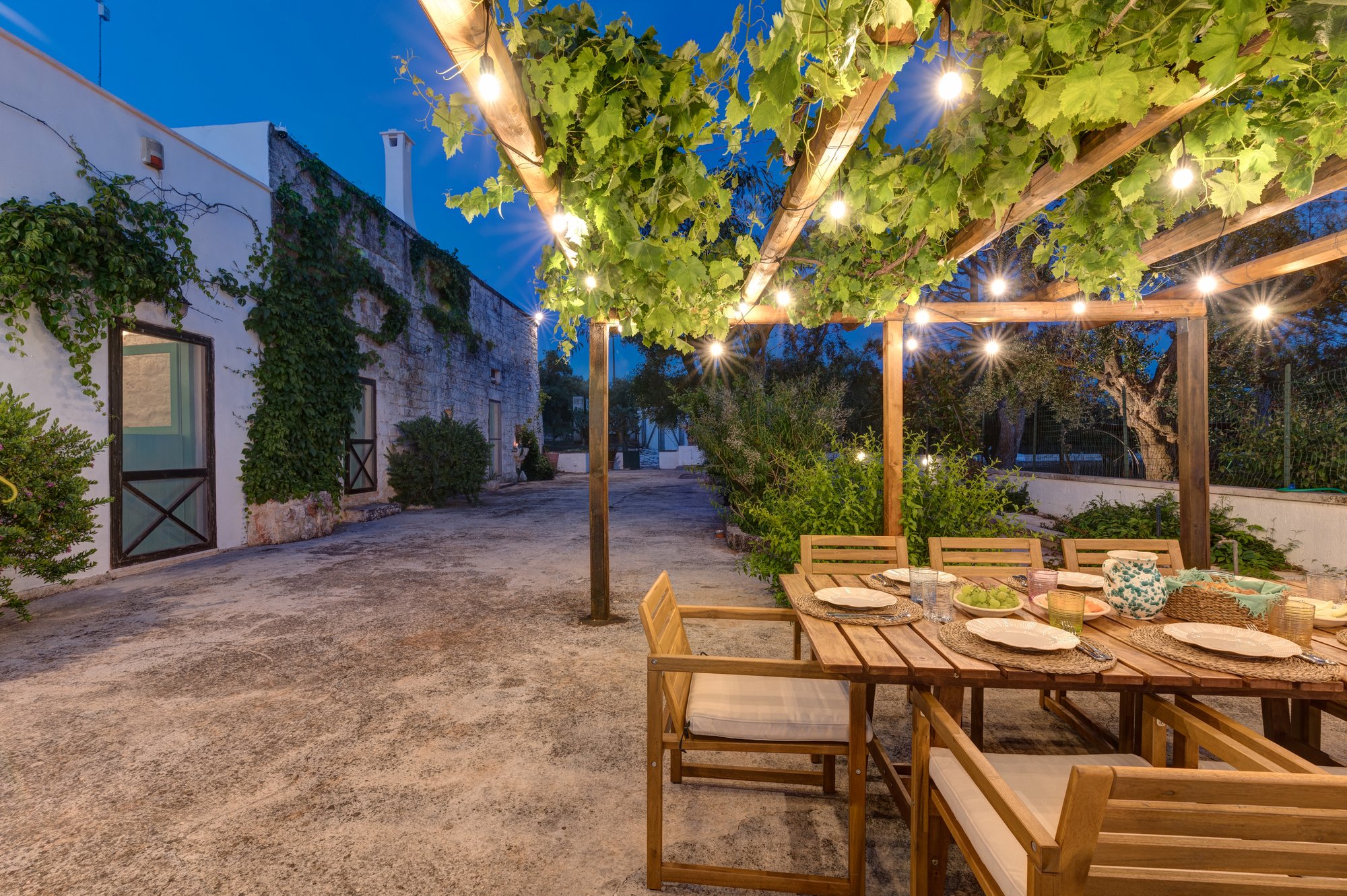 The pergola and courtyard lit up in the evening at Masseria Bel Cortile, Ostuni