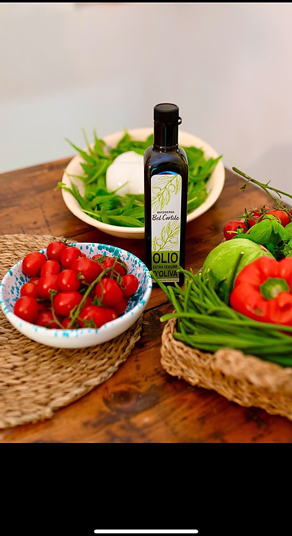 Bel Cortile olive oil on the table with fresh produce